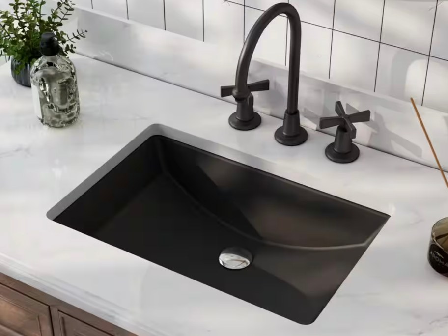 black sink with black facuet with marble countertop