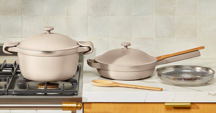 beige pot, pan and strainer on countertop