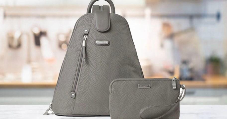 gray backpack and wristlet sitting on countertop