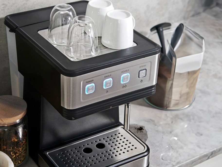 stainless steel and black espresso machine with cups on top 