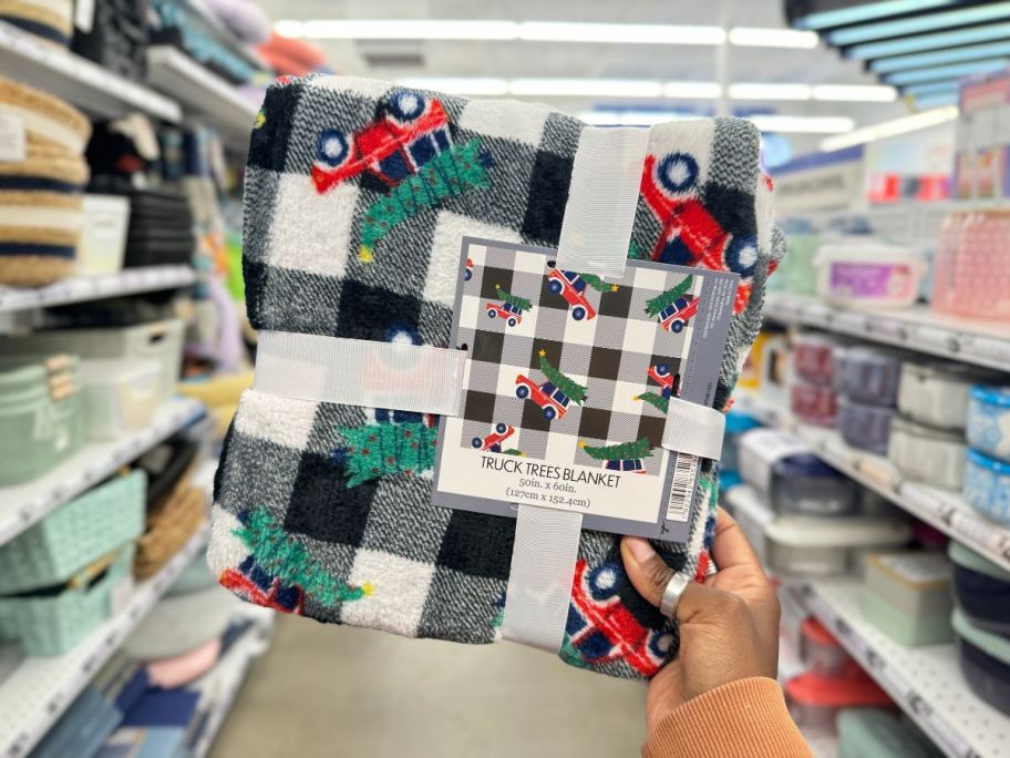 Truck Trees Christmas Blanket being held by hand in store