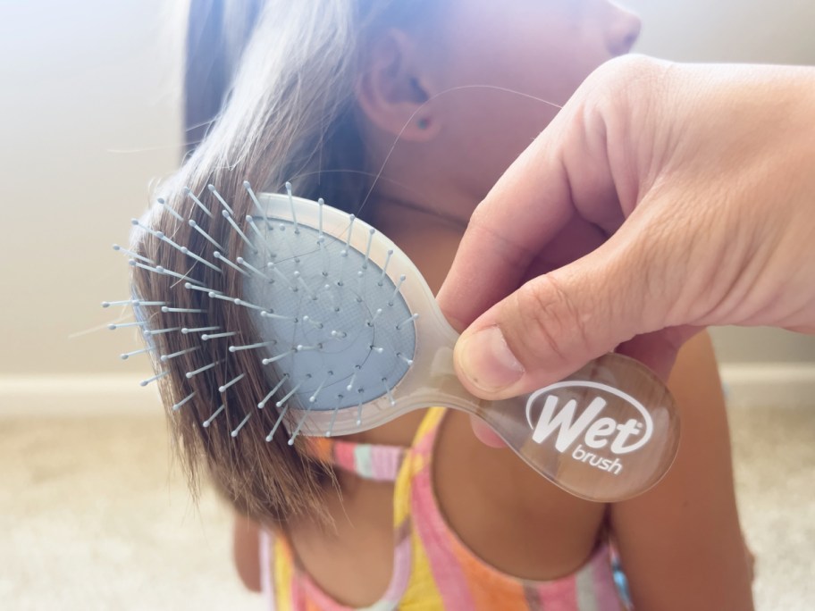 brush childs hair with little detangling brush