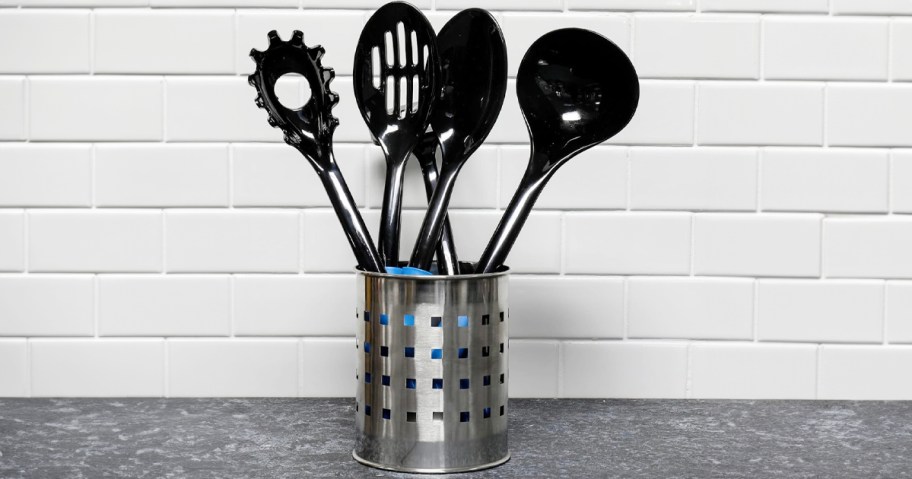 black utensils sitting in stainless steel container on countertop 