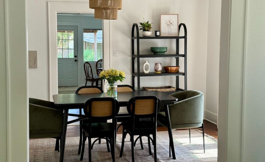 dining room with modern black rattan chairs and green upholstered chairs