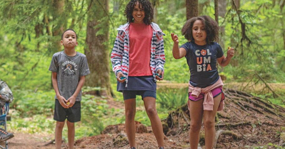 three kids in forest wearing columbia clothes