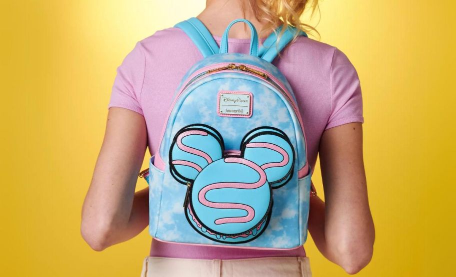 a girl wearing a disney mini backpack rear view