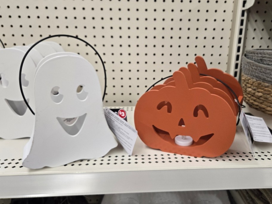 metal white ghost and orange pumpkin lanterns on shelf