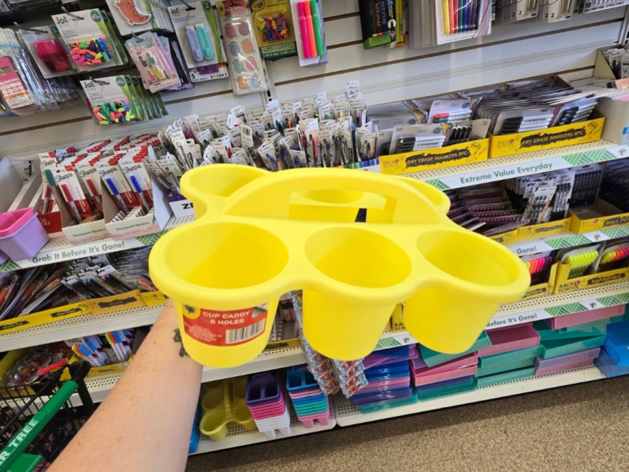 hand holding a yellow 6 cup holder caddy