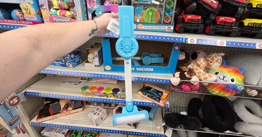 hand holding blue toy vacuum in dollar tree