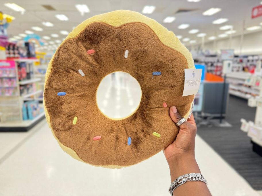 Bullseye's Playground donut pillow being held by hand in store