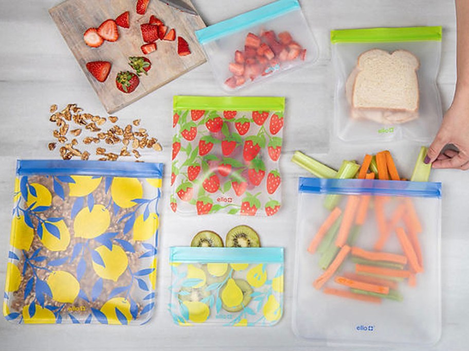 food storage plastic bags with fruit and veggies inside on table