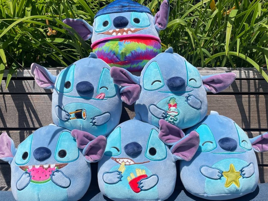 Disney Stitch summer-themed Squishmallows are piled on an outdoor table.