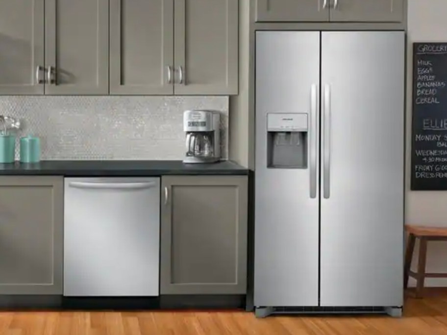 stainless steel refrigerator in kitchen with gray cabinets 