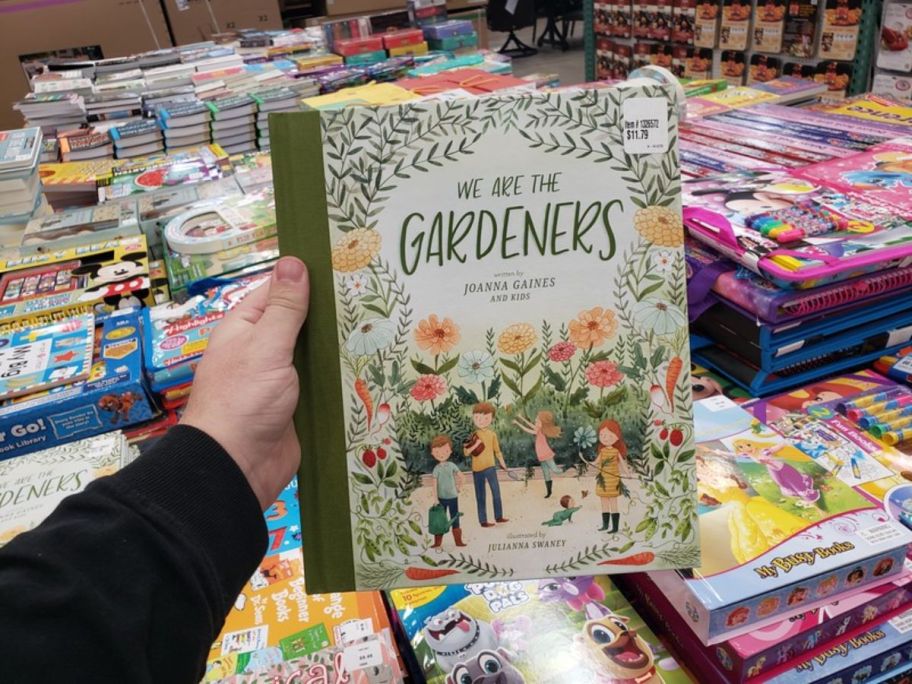 womans hand holding a gardening book at a costco warehouse