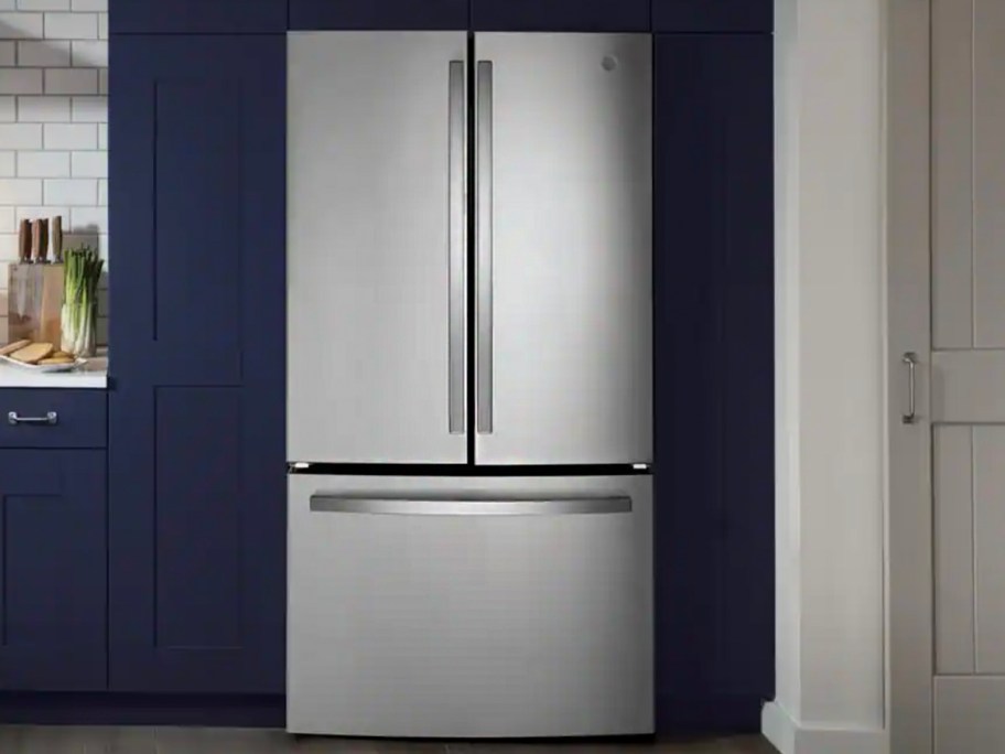 stainless steel refrigerator with blue cabinets around it 