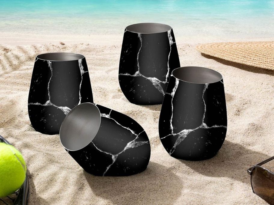 FineDine Stainless Steel Stemless Wine Glass Set of Four in Polished Raven Marble in sand on beach