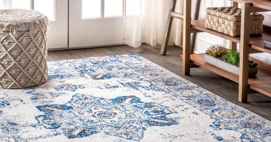 blue and white rug laying on floor with stool on it 
