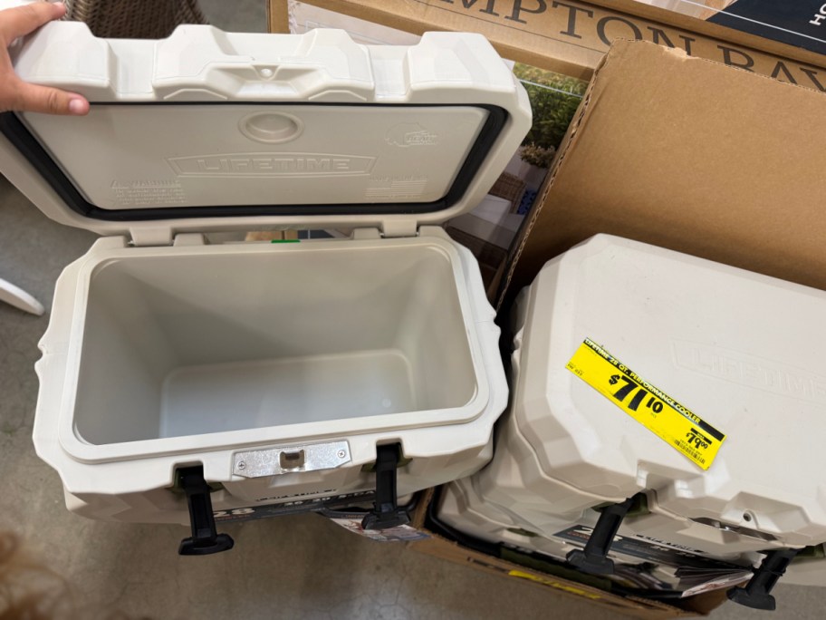 Two white Lifetime coolers, one open showing the empty interior and another closed with a yellow clearance sticker.