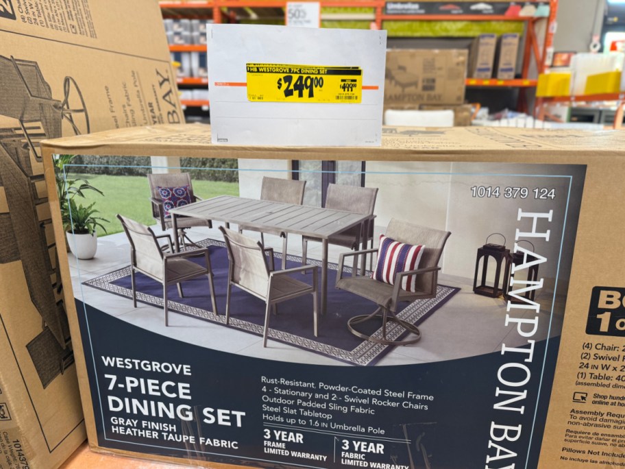 A cardboard box for a Hampton Bay 7-piece patio dining set with a yellow clearance price tag of $249.00 placed on top.