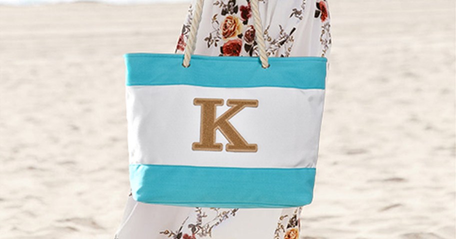 woman holding blue initial beach tote at beach