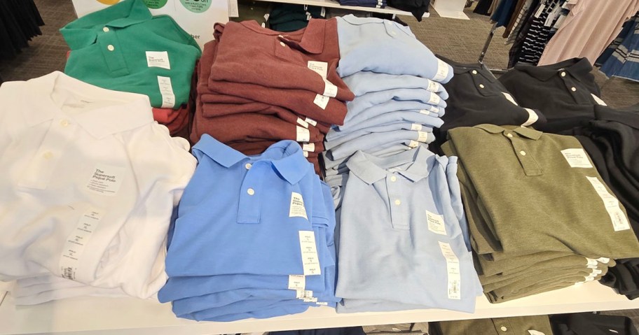 mens polo shirts in multiple colors sitting on table at store
