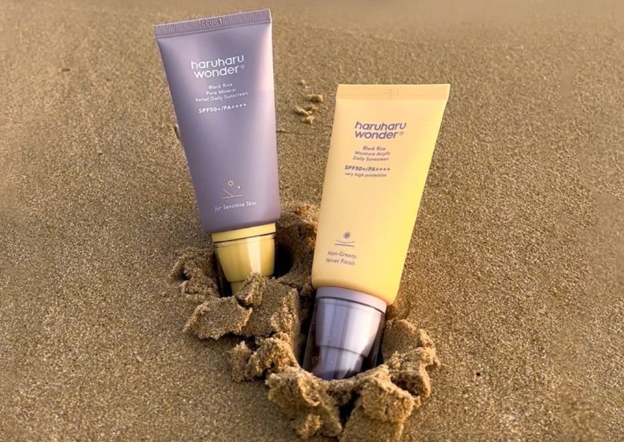 two sunscreens in the sand