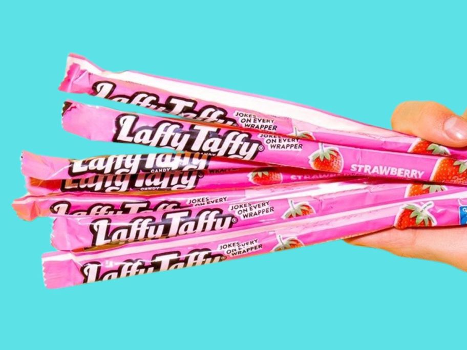 hand holding a bunch of laffy taffy strawberry candy