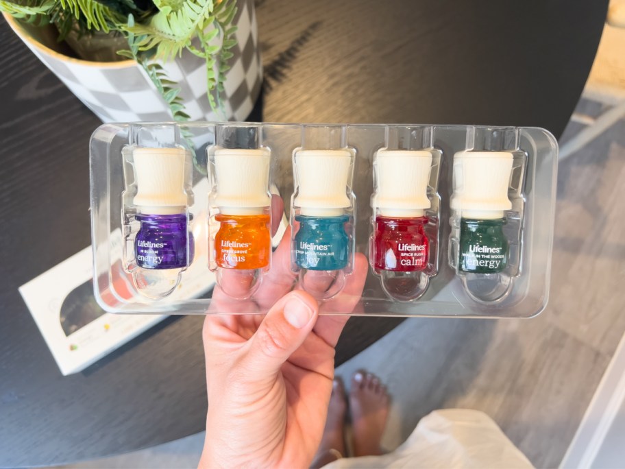 hand holding 5-pack essential oils
