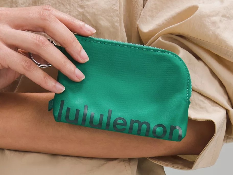 woman holding a green lululemon clippable card pouch