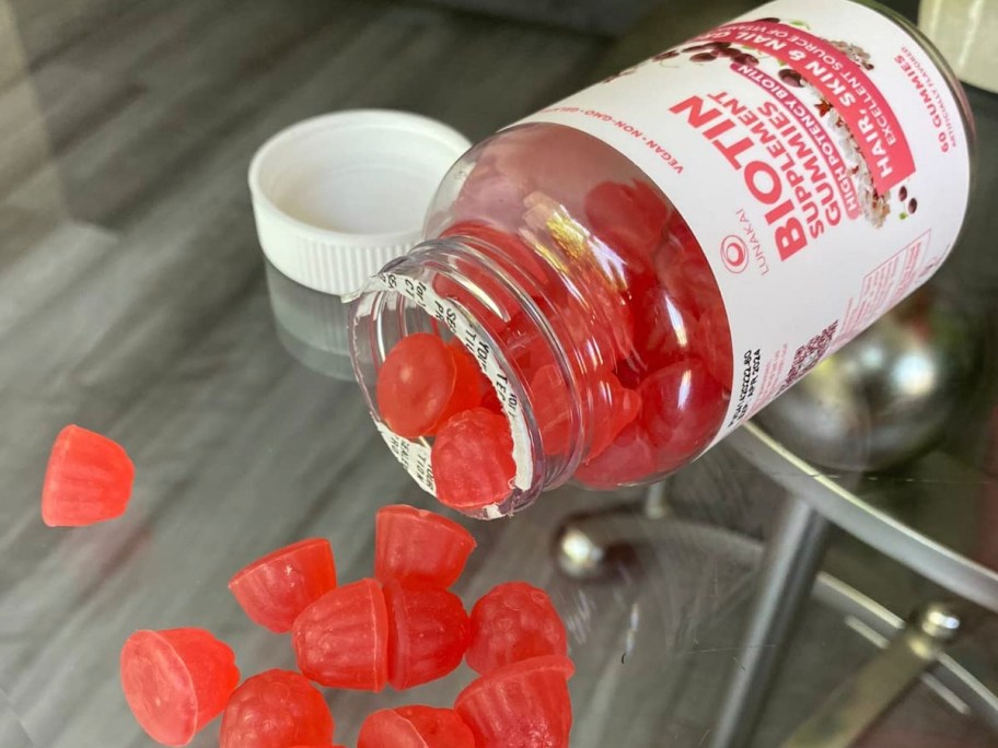 lunakai biotin gummies bottle with gummies laying out in front of it on table