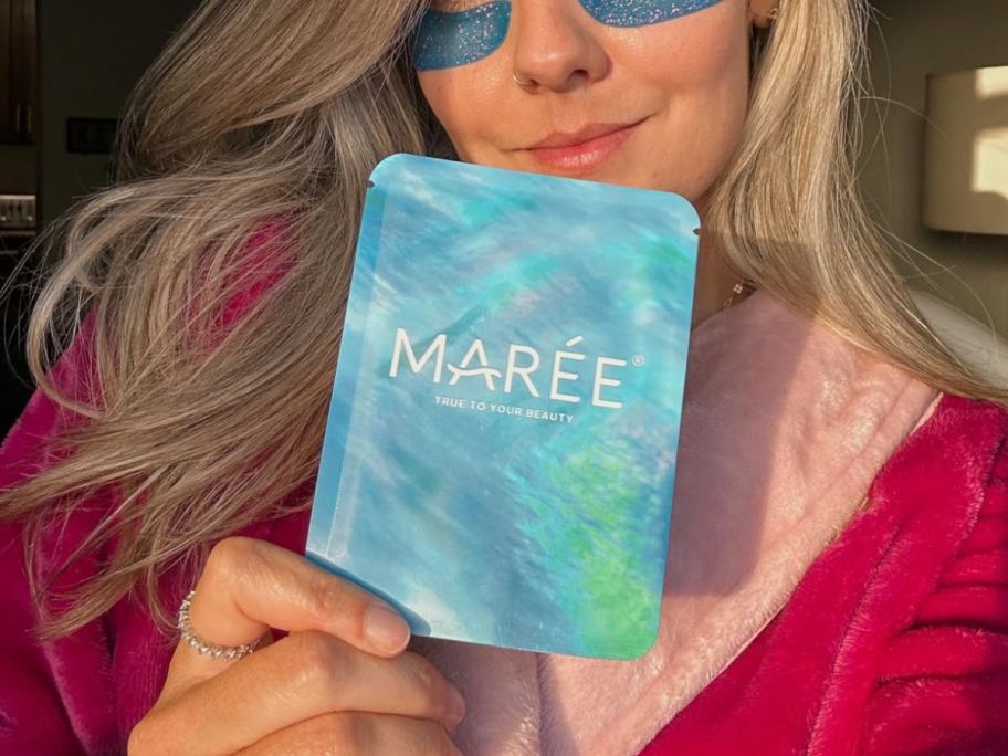 woman wearing Maree Marine Collagen Under Eye Gels and holding a package of them