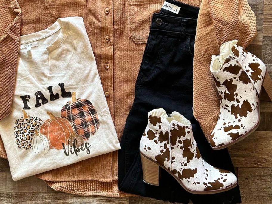 An Outfit with Maurices Cow Print Boots, a fall tee, black jeans and a shacket