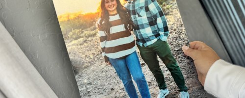 hand holding metal print on wall