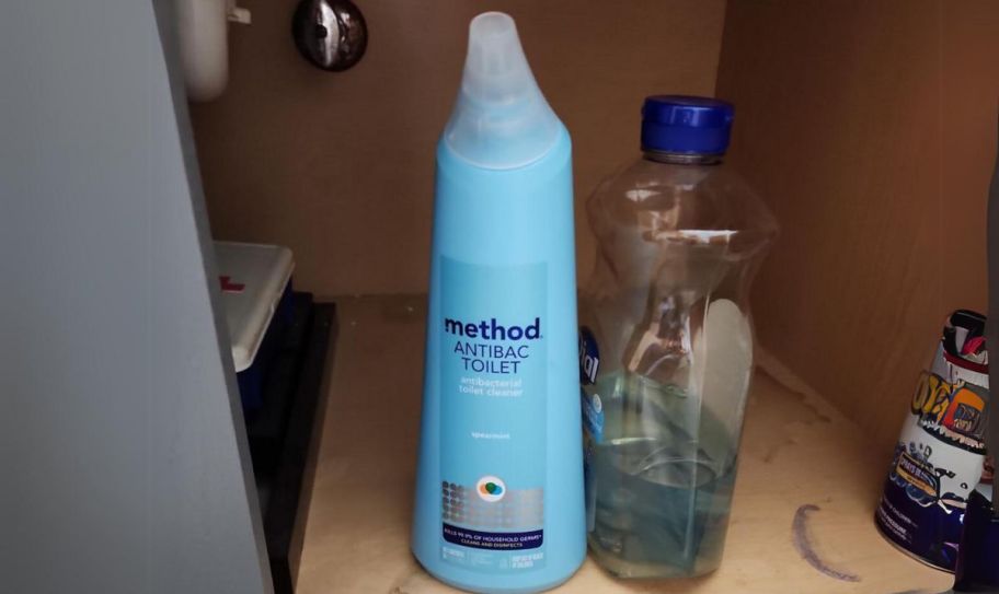 a bottle of method toilet bowl cleaner under a sink in a cabinet