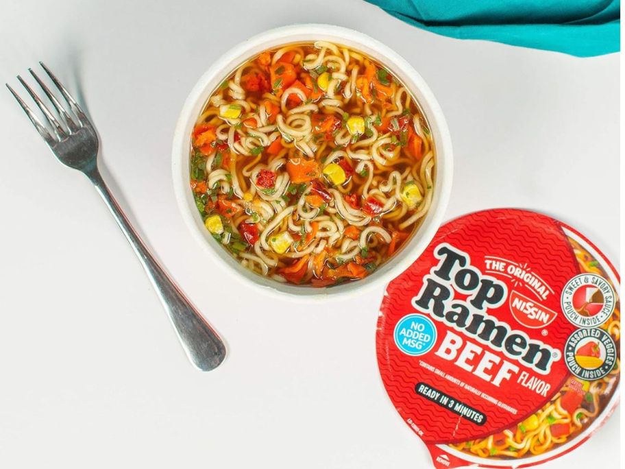 Nissin Top Ramen Noodle Soup Beef Flavor 3.28oz on table in bowl with fork next to it