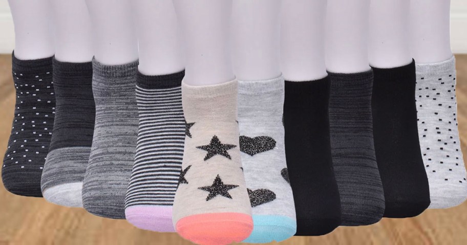10 pairs of socks on mannequins feet on hardwood floor