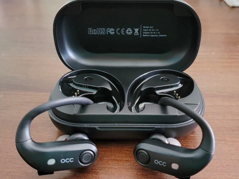 occiam over the ear earbuds sitting outside of case