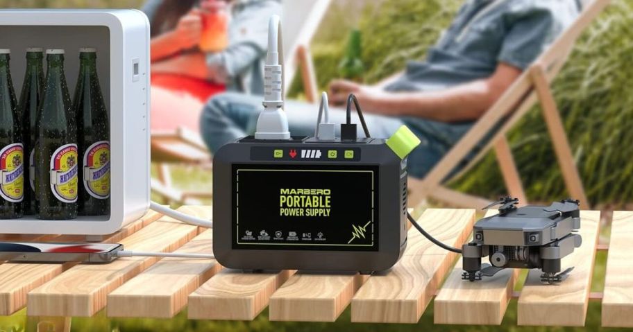 MARBERO Portable Power Station charging a small refrigerator and drone at campsite on picnic table