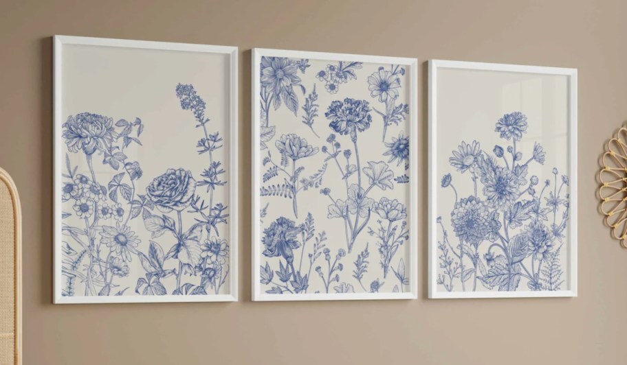 three blue floral art pieces on wall