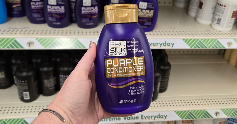 hand holding pro silk purple conditioner bottle 