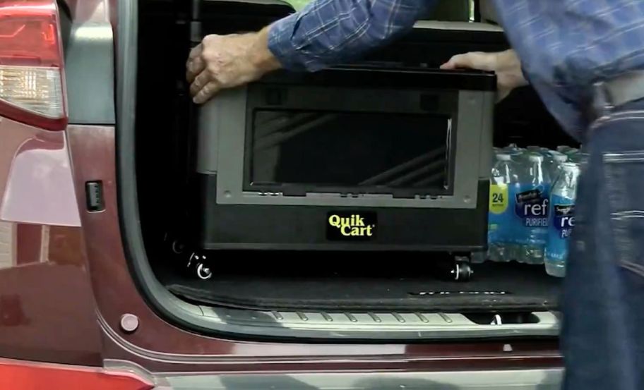 a man placing a quick crate in the back of an suv