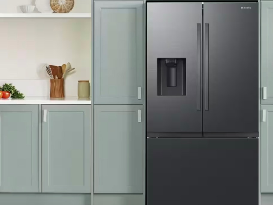 dark stainless steel refrigerator with green cabinets 