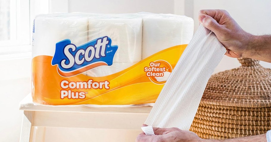 scott comfort plus toilet paper pack with hands holding toilet paper
