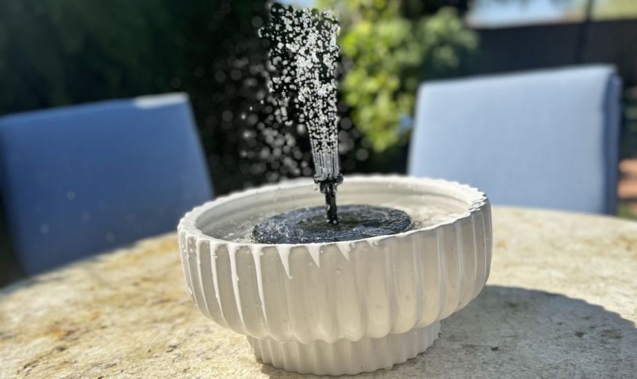 a solar tabletop fountain in a planter