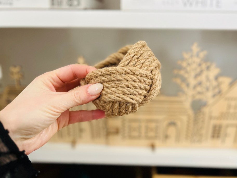 hand holding jute planter in front of christmas houses