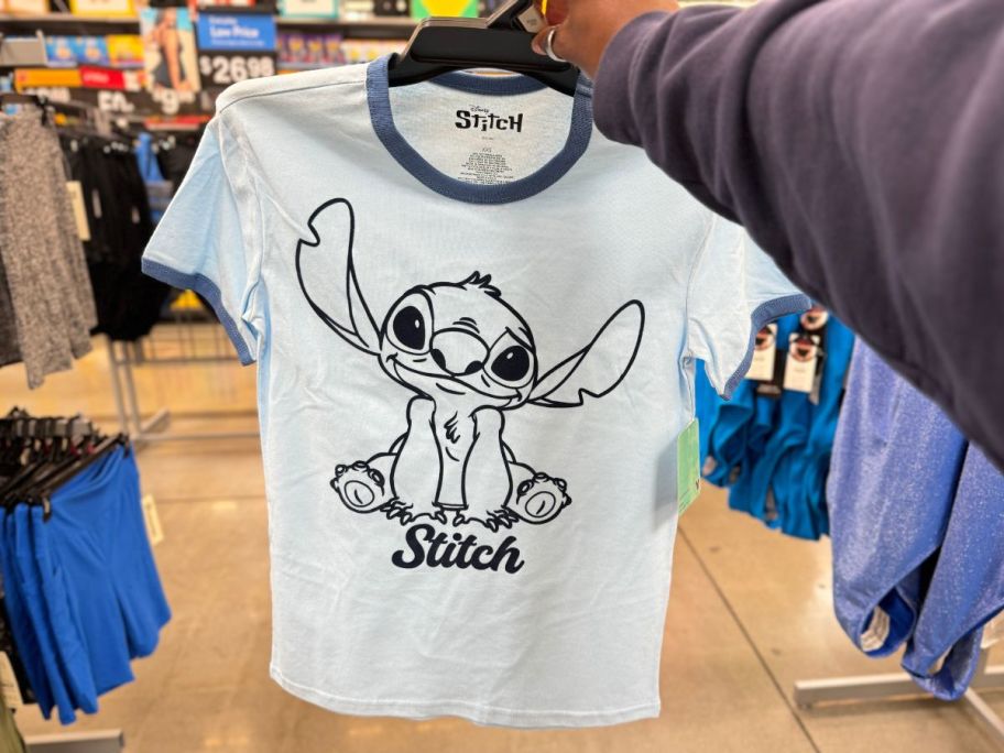 a womans hand holding a stitch tee