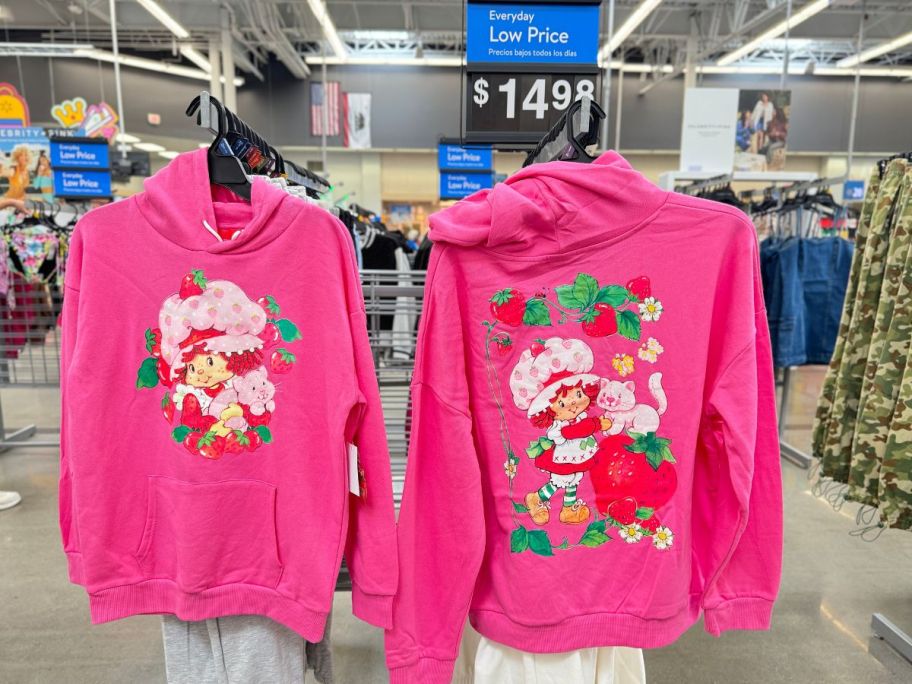 a hot pink strawberry shortcake hoodie on a rack in a store
