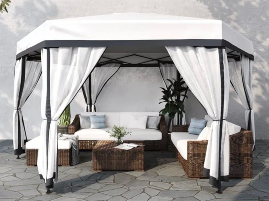 white and black pop up gazebo on patio with furniture underneath