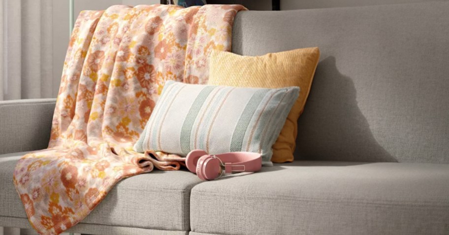 yellow and white and green pillows on gray couch