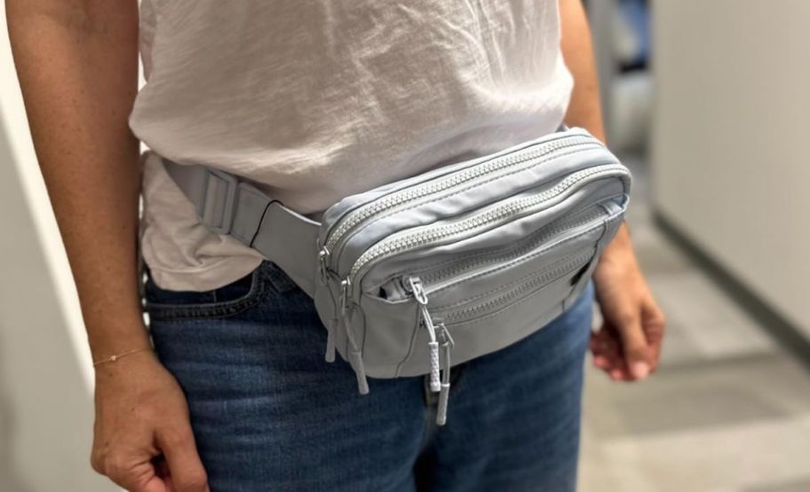 a woman wearing a gray belt bag